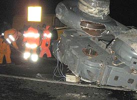 Un utilaj greu a ajuns pe drum dupa ce s-a rasturnat de pe autotractorul care il transporta