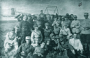 Un grup de ofiteri-elevi piloti in fata trainerului „Pinguin”; in mijlocul grupului slt. Raducanescu S. Nicolae, marcat cu o bulina pe buzunarul din dreapta al vestonului. Tecuci, 1921