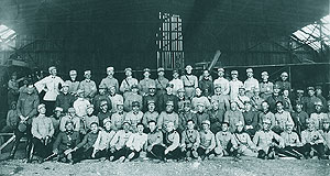 Ofiteri profesori de zbor si ofiteri elevi, in fata unui avion Brandenburg (captura de razboi), adapostit intru-un hangar la Tecuci 1921. In randul de jos, la mijloc, marcat cu "X" se afla Slt. Raducanescu, viitorul meu tata vitreg.